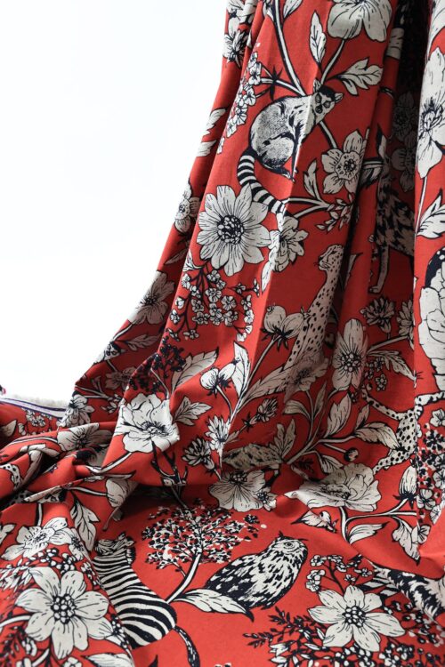 Tissu japonais Echino animaux de la savane et fleurs écru sur fond rouge, drapé