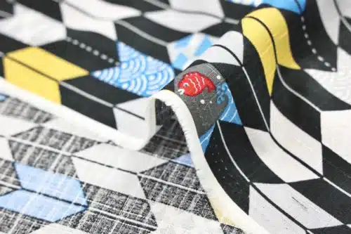 Japanese arrow feather yagasuri fabric graphic on a black background, fold with selvedge and reverse side