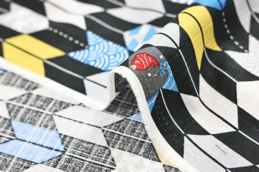 Japanese arrow feather yagasuri fabric graphic on a black background, fold with selvedge and reverse side