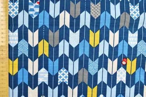 Japanese arrow feather yagasuri fabric in tonal indigo blue, flat with ruler