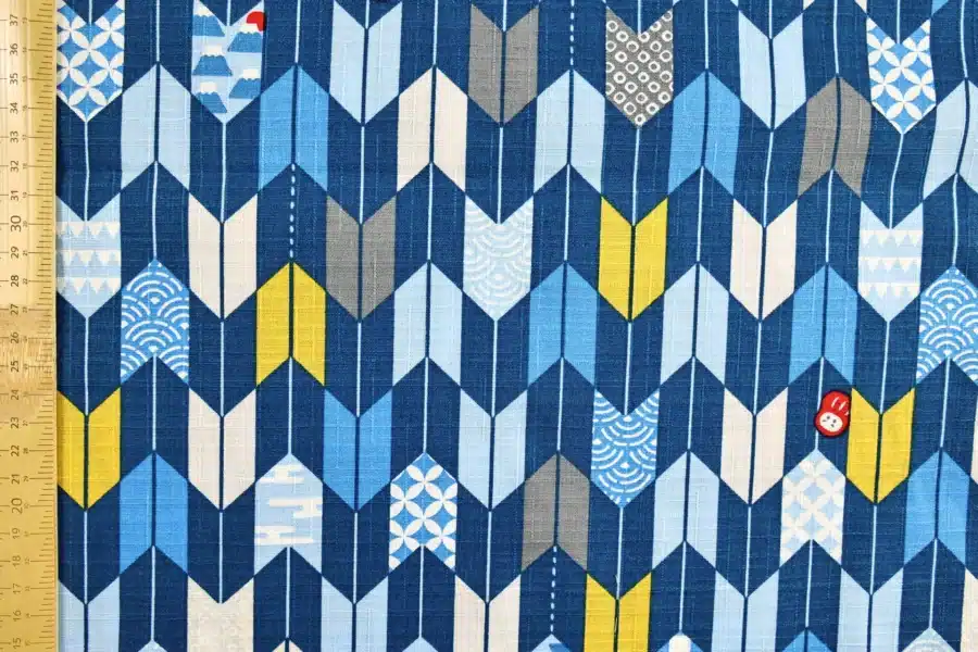 Japanese arrow feather yagasuri fabric in tonal indigo blue, flat with ruler