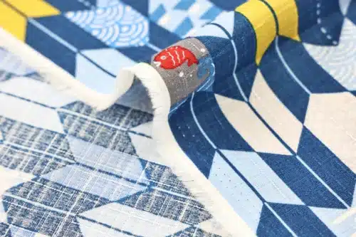 Japanese arrow feather yagasuri fabric in tonal indigo blue, fold with selvedge and reverse side