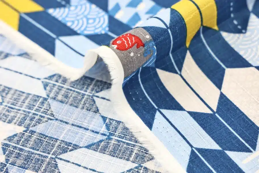 Japanese arrow feather yagasuri fabric in tonal indigo blue, fold with selvedge and reverse side