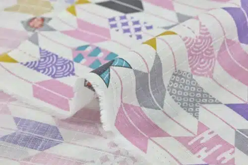 Japanese arrow feather yagasuri fabric pink and mauve on a white background, fold with selvedge and reverse side