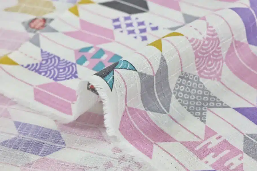 Japanese arrow feather yagasuri fabric pink and mauve on a white background, fold with selvedge and reverse side