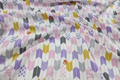 Japanese arrow feather yagasuri fabric pink and mauve on a white background, crumpled flat