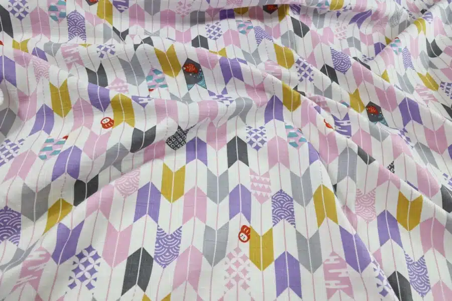 Japanese arrow feather yagasuri fabric pink and mauve on a white background, crumpled flat