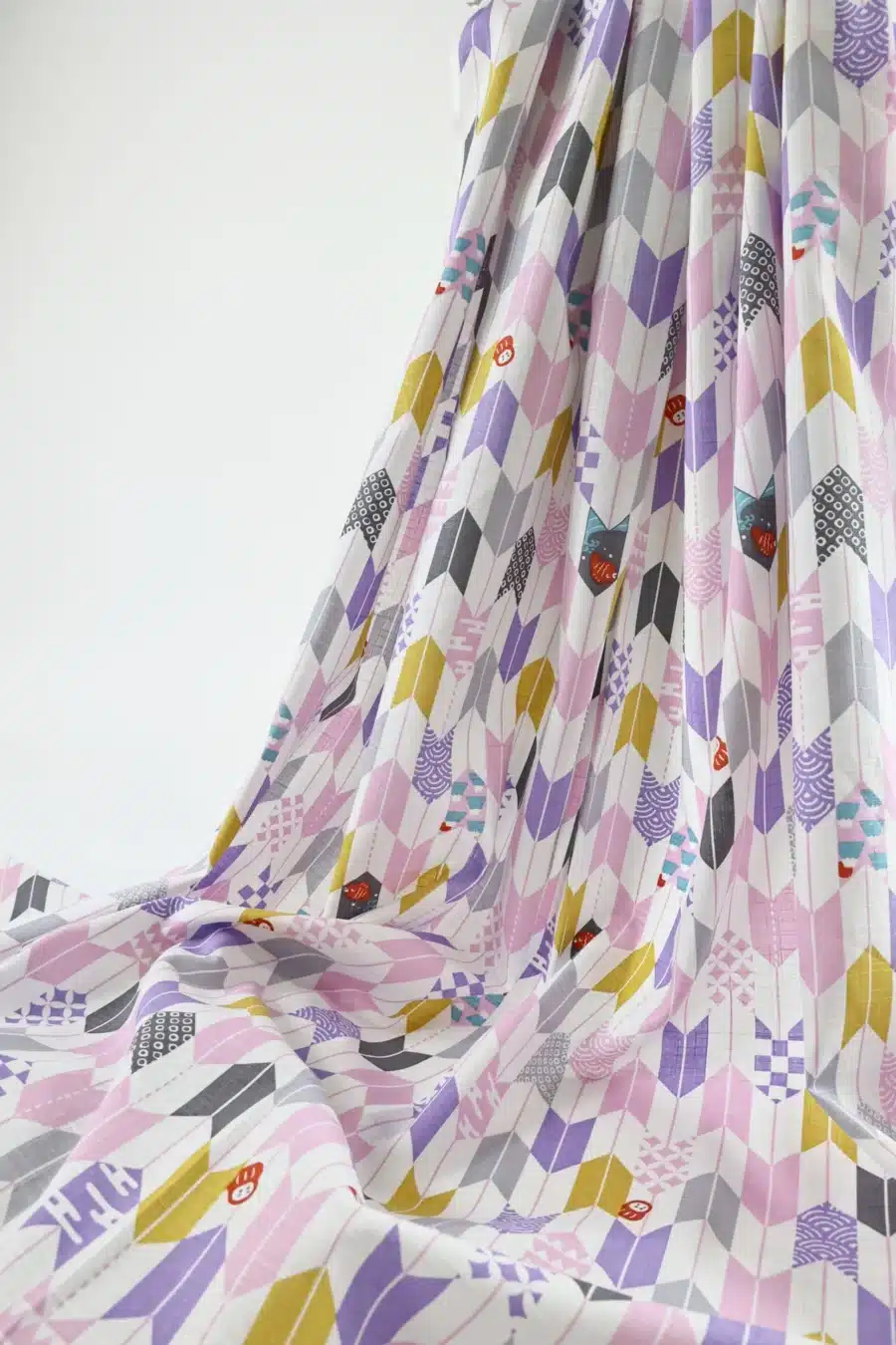 Japanese arrow feather yagasuri fabric pink and mauve on a white background, draped