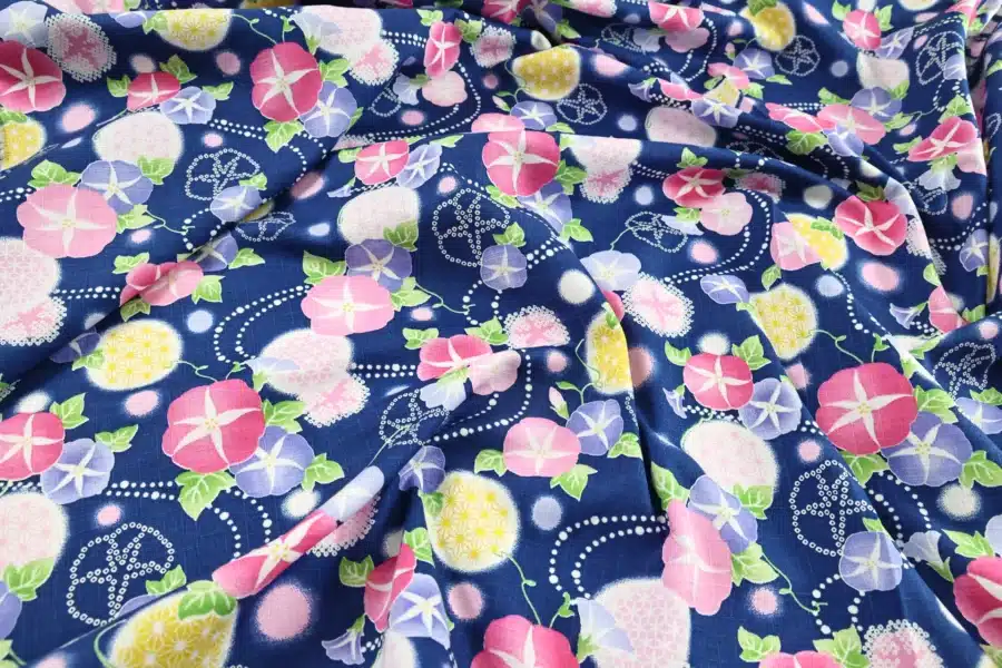 Japanese morning glory asagao fabric with pink and mauve flowers on a navy blue background, crumpled flat