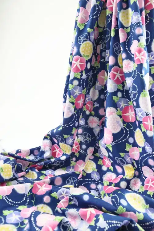 Japanese morning glory asagao fabric with pink and mauve flowers on a navy blue background, draped