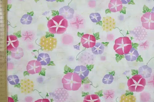 Japanese morning glory asagao fabric with pink and mauve flowers on an off-white background, flat with ruler