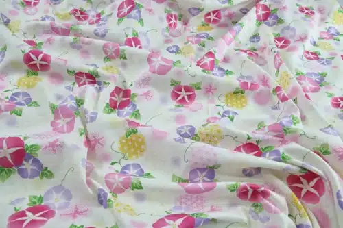 Japanese morning glory asagao fabric with pink and mauve flowers on an off-white background, crumpled flat