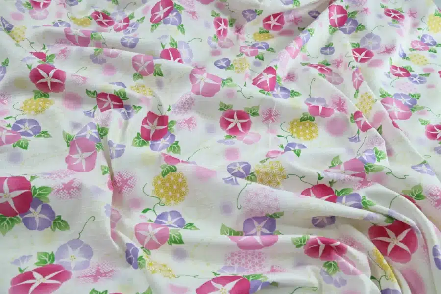 Japanese morning glory asagao fabric with pink and mauve flowers on an off-white background, crumpled flat