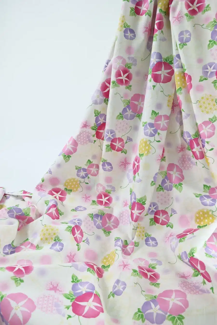 Japanese morning glory asagao fabric with pink and mauve flowers on an off-white background, draped
