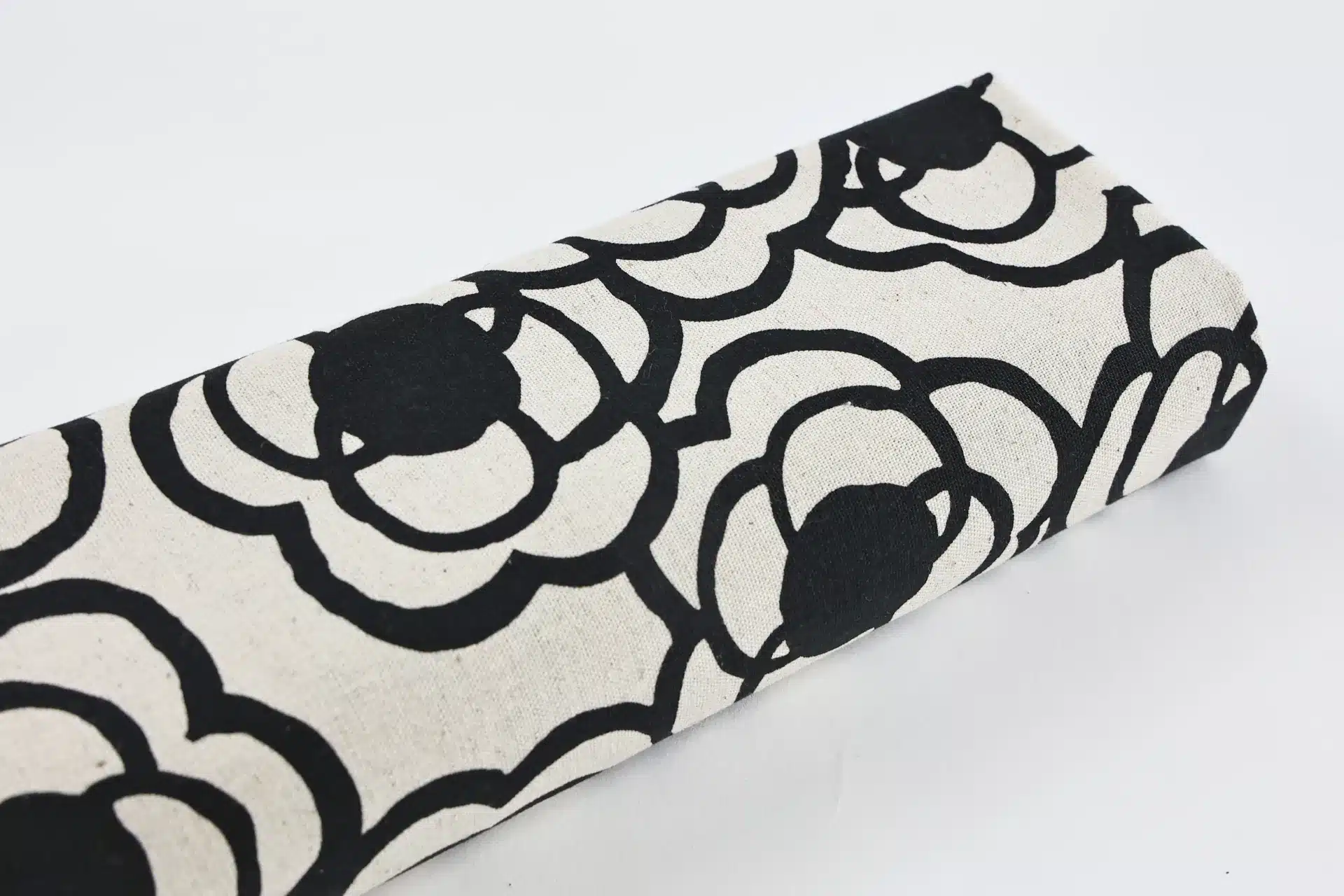 Japanese canvas fabric black camellias on ecru, Kobayashi cotton and linen canvas, fabric roll on white background