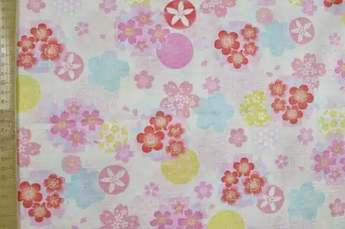 Tissu japonais dobby sakura et cercles yukiwa pastel sur fond ivoire, à plat avec règle