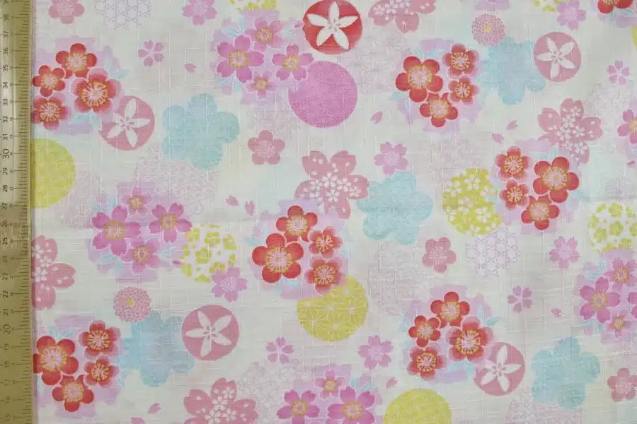 Tissu japonais dobby sakura et cercles yukiwa pastel sur fond ivoire, à plat avec règle