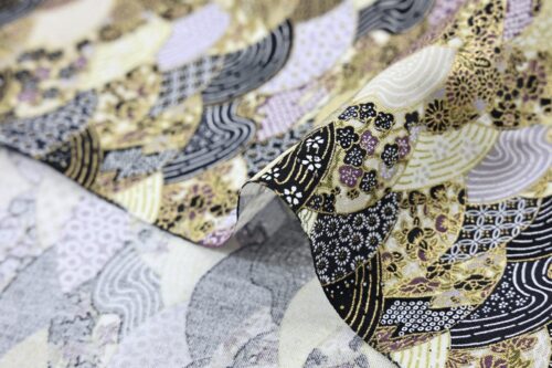 Tissu japonais vagues multi motifs traditionnels dorés, tons noir, or et mauve, gros plan sur le pli