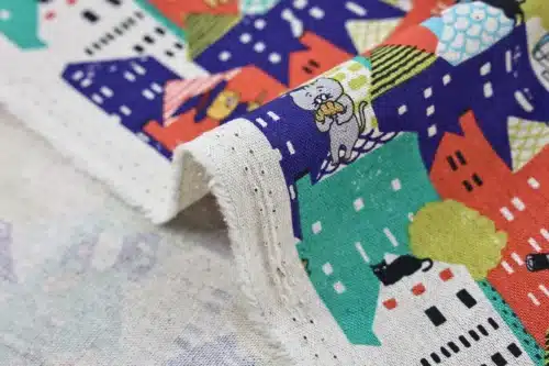 Japanese witch cat village fabric multicolor, Kobayashi cotton and linen canvas, close-up of fold and selvage
