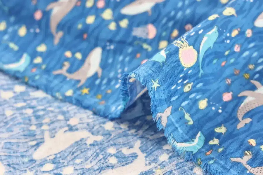 Japanese double gauze whale and dolphin fabric blue background, draped