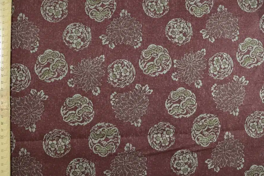 Tissu Japonais médaillons fleuris hanamaru fond bordeaux, à plat avec règle