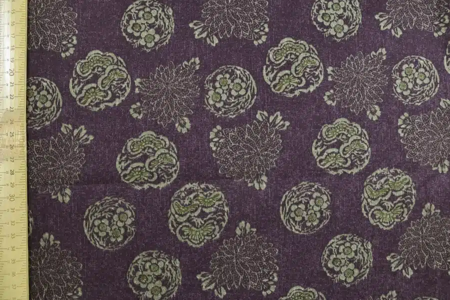 Tissu Japonais médaillons fleuris hanamaru fond violet, à plat avec règle