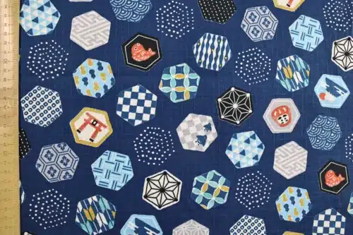Tissu japonais hexagones et motifs traditionnels fond bleu marine, à plat avec règle