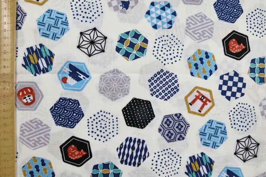 Tissu japonais hexagones et motifs traditionnels fond blanc, à plat avec règle